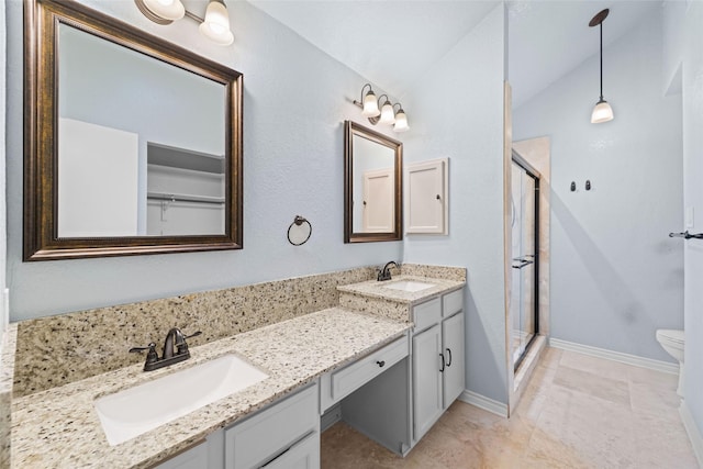 bathroom with a sink, a stall shower, and double vanity