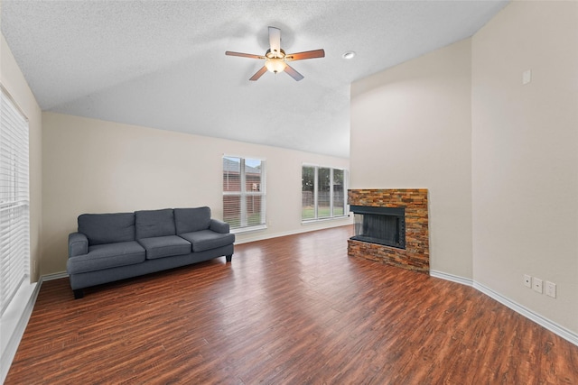 living area with a fireplace, a ceiling fan, baseboards, and wood finished floors