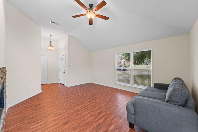 living area featuring visible vents, baseboards, vaulted ceiling, wood finished floors, and a ceiling fan