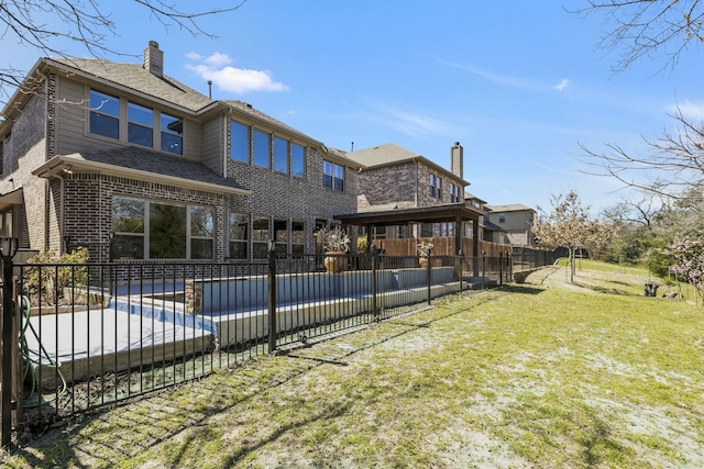 rear view of house with a chimney, a patio area, a swimming pool, brick siding, and a shingled roof