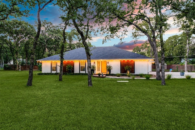 single story home featuring a yard, a shingled roof, driveway, and fence