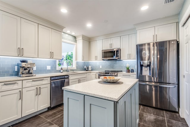 kitchen with a sink, stainless steel appliances, white cabinetry, tasteful backsplash, and a center island