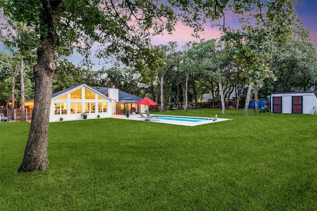 view of yard featuring an outdoor pool, a storage unit, an outdoor structure, and a fenced backyard