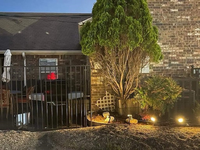 exterior space featuring brick siding and gutters