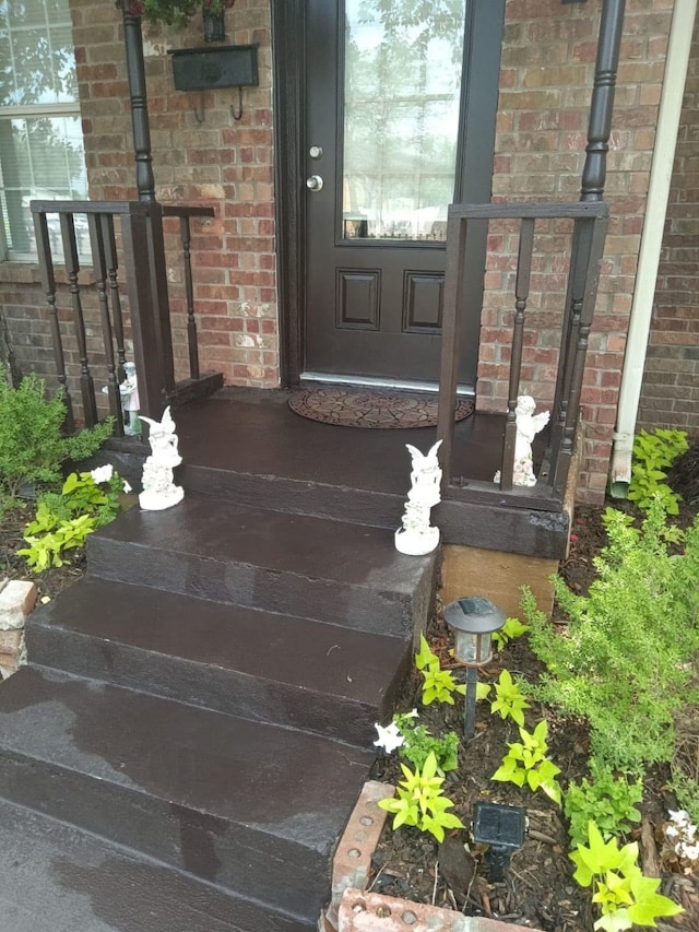 view of exterior entry featuring brick siding