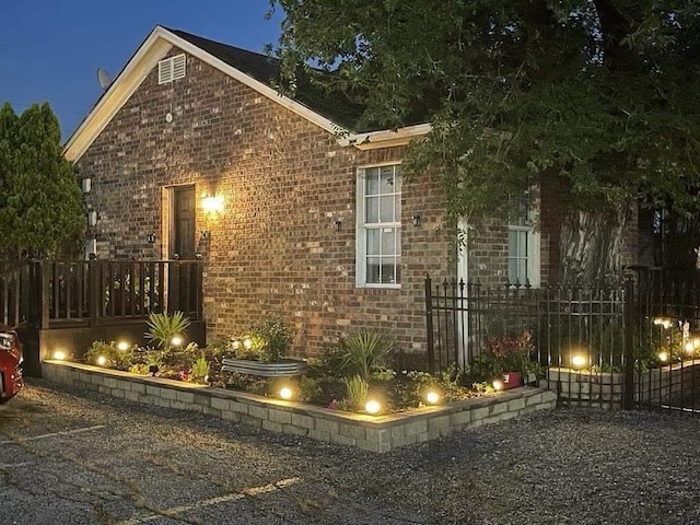 property exterior at twilight featuring brick siding