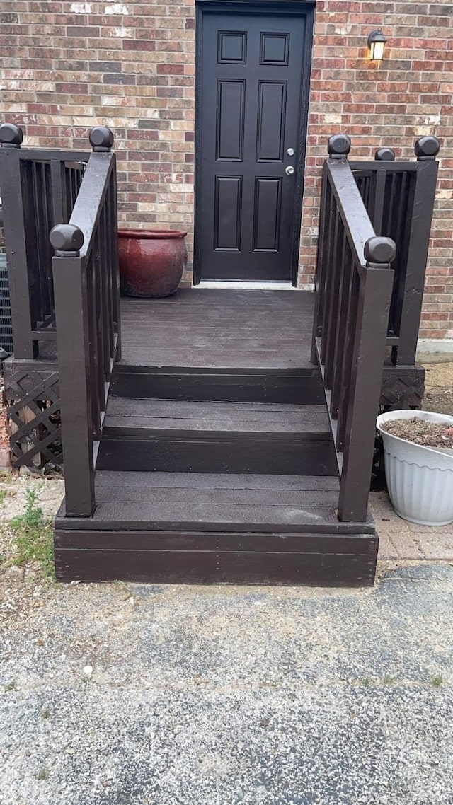 entrance to property with cooling unit and brick siding