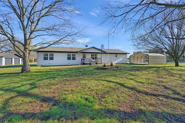 view of front facade featuring brick siding, a detached carport, a front lawn, a chimney, and an outdoor structure