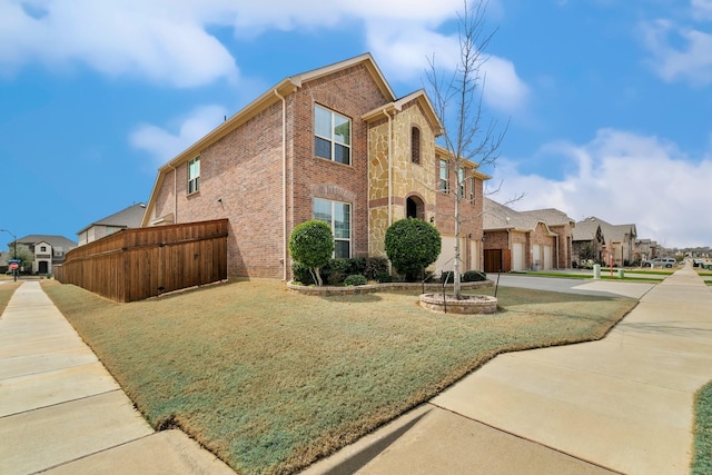 view of property exterior with a yard, brick siding, concrete driveway, and fence