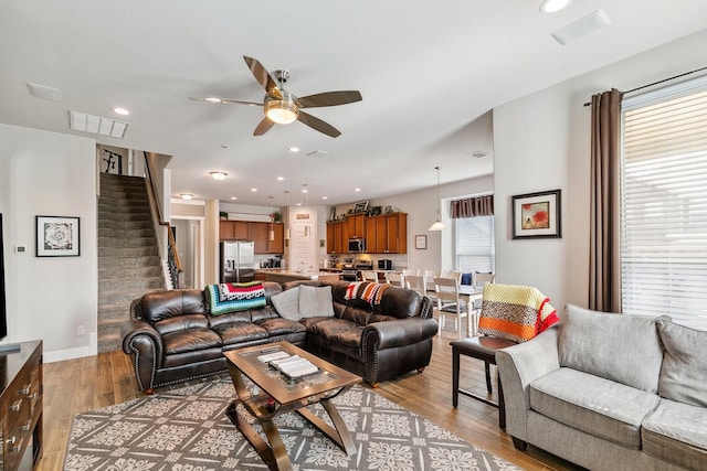 living room with visible vents, recessed lighting, stairway, light wood finished floors, and ceiling fan