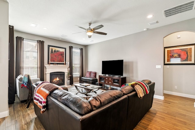 living area featuring light wood-style flooring, baseboards, visible vents, and ceiling fan