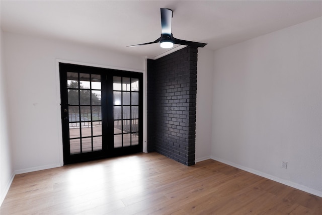 spare room with french doors, baseboards, a ceiling fan, and wood finished floors