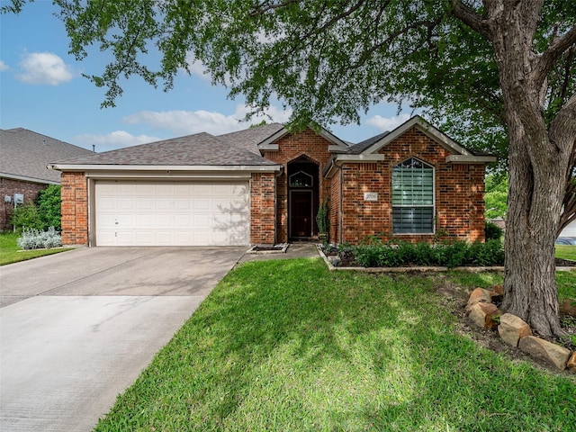single story home with a garage, concrete driveway, brick siding, a front lawn, and roof with shingles