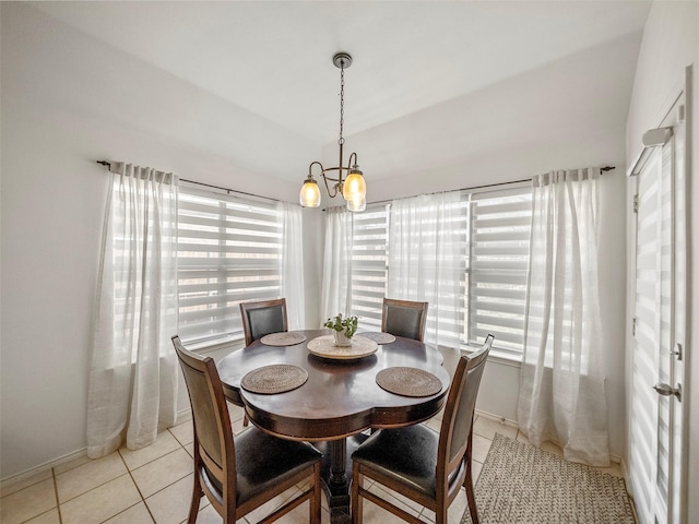 dining space featuring light tile patterned floors, a chandelier, and baseboards