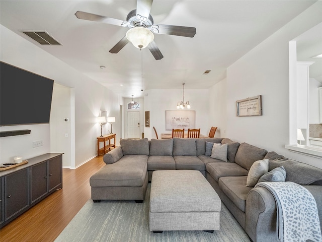 living room with baseboards, visible vents, light wood finished floors, and ceiling fan