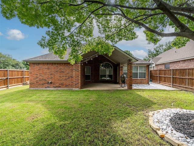 back of property with brick siding, a patio, and roof with shingles