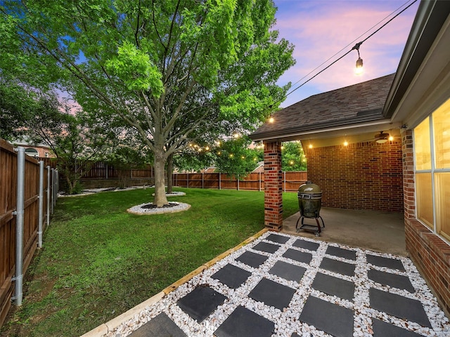 yard at dusk featuring a patio area