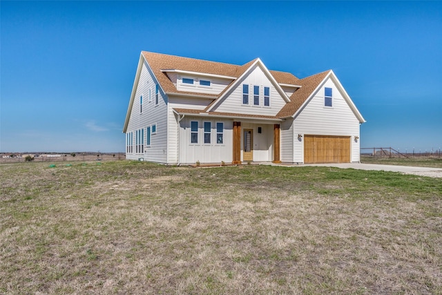 view of front of house with a garage, concrete driveway, a shingled roof, and a front yard