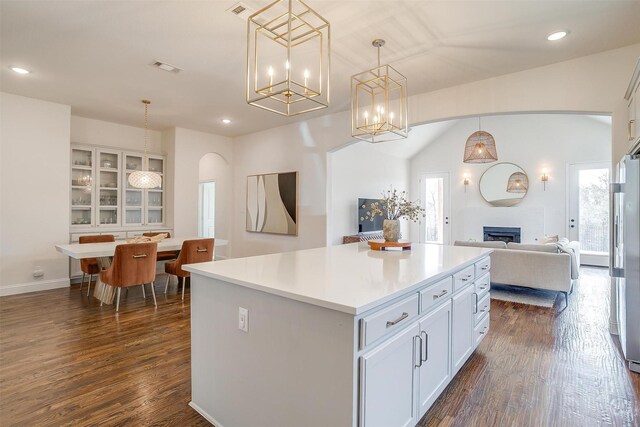 kitchen featuring decorative light fixtures, dark wood finished floors, a fireplace, and white cabinetry