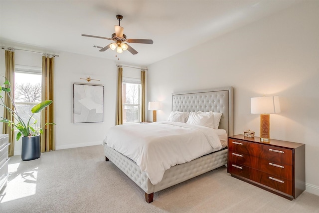 bedroom with baseboards, multiple windows, and light colored carpet