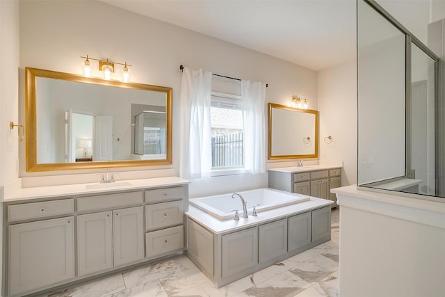 bathroom with two vanities, a stall shower, a sink, a garden tub, and marble finish floor