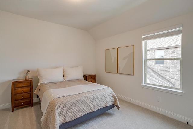 bedroom with baseboards, light carpet, and vaulted ceiling