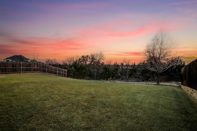 yard at dusk with a fenced backyard