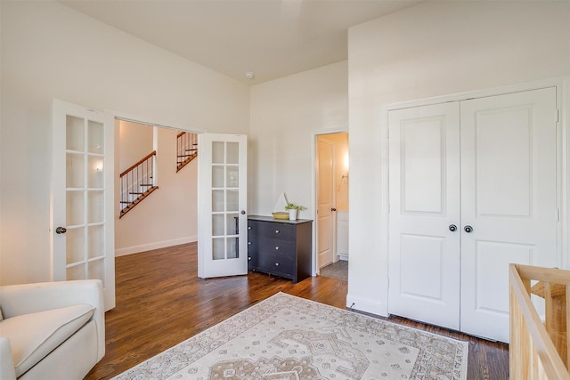 unfurnished bedroom featuring dark wood-style floors, french doors, baseboards, and a closet