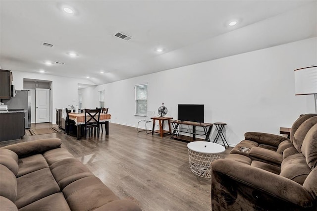 living area with recessed lighting, wood finished floors, visible vents, and baseboards