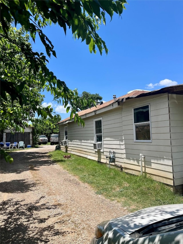 view of side of property with cooling unit, driveway, and fence