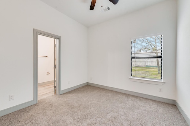 empty room featuring visible vents, baseboards, light colored carpet, and a ceiling fan