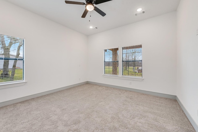 carpeted spare room featuring recessed lighting, visible vents, baseboards, and ceiling fan