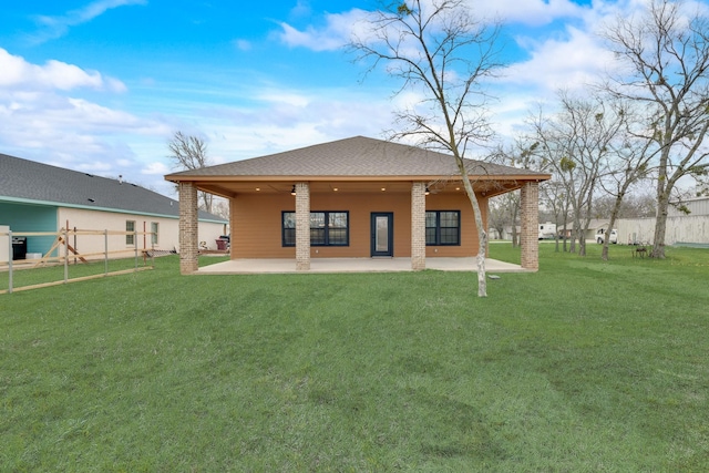 back of house featuring a patio, a lawn, roof with shingles, and fence