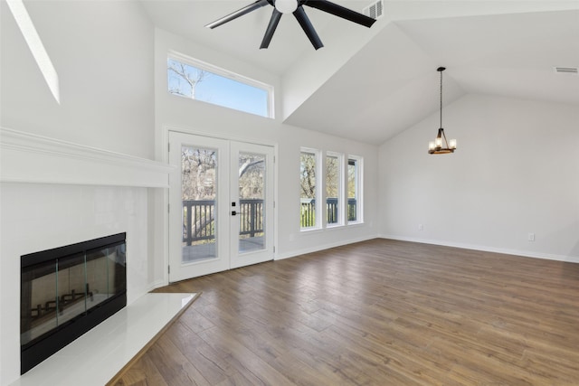 unfurnished living room featuring wood finished floors, baseboards, visible vents, a tile fireplace, and french doors