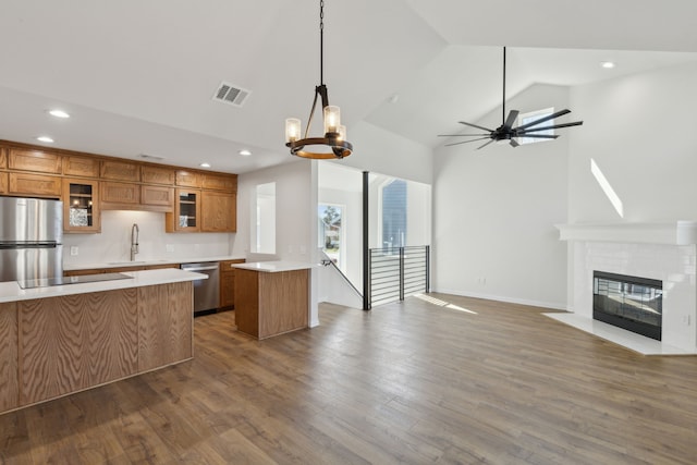 kitchen with brown cabinetry, visible vents, light countertops, appliances with stainless steel finishes, and open floor plan