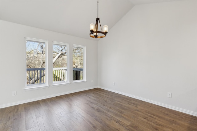 unfurnished dining area with dark wood-style floors, a notable chandelier, baseboards, and vaulted ceiling