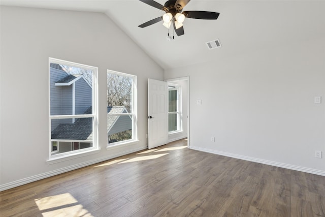 unfurnished room with visible vents, a ceiling fan, wood finished floors, baseboards, and lofted ceiling