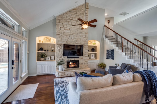 living room featuring dark wood-type flooring, ornamental molding, a fireplace, baseboards, and stairs