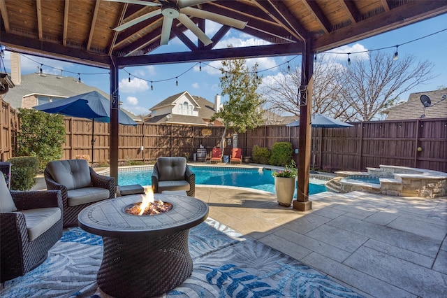 view of patio / terrace featuring ceiling fan, a gazebo, a fenced backyard, and an outdoor fire pit