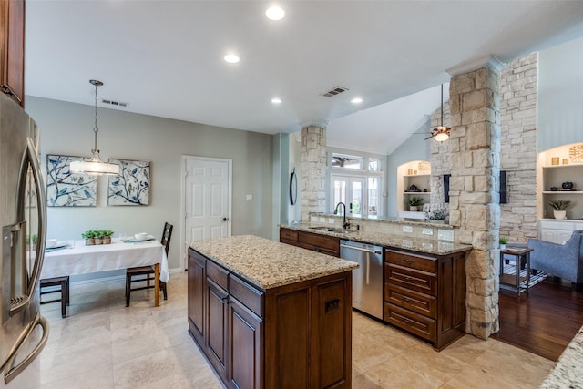 kitchen featuring visible vents, a sink, a center island, appliances with stainless steel finishes, and hanging light fixtures