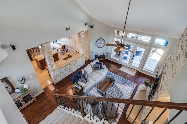 living area with visible vents, ornamental molding, high vaulted ceiling, and wood finished floors