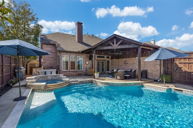 view of pool featuring grilling area, a pool with connected hot tub, french doors, a fenced backyard, and a patio