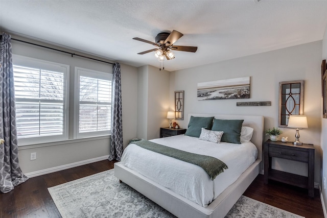 bedroom featuring baseboards, wood finished floors, and a ceiling fan