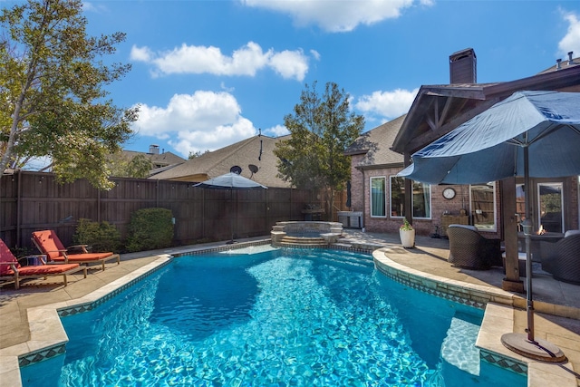 view of pool featuring a pool with connected hot tub, a fenced backyard, and a patio area