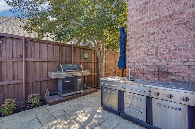 view of patio / terrace featuring area for grilling, a sink, and fence