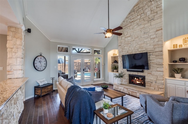 living area with built in shelves, dark wood-style floors, a fireplace, french doors, and crown molding