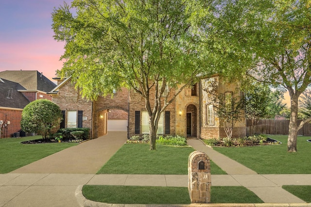 view of front of house featuring brick siding, a front lawn, and fence