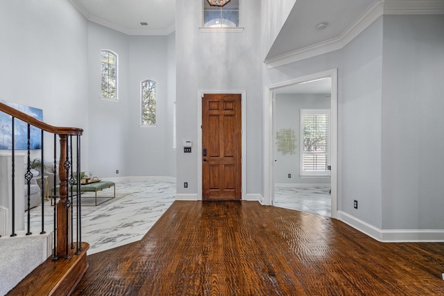 foyer entrance featuring stairs, wood finished floors, baseboards, and ornamental molding