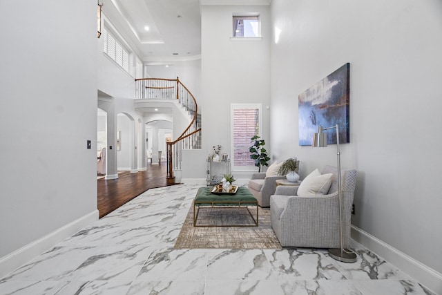 foyer entrance with stairs, a healthy amount of sunlight, arched walkways, and baseboards