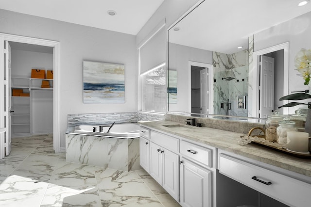 full bath featuring a walk in closet, marble finish floor, a marble finish shower, a bath, and vanity